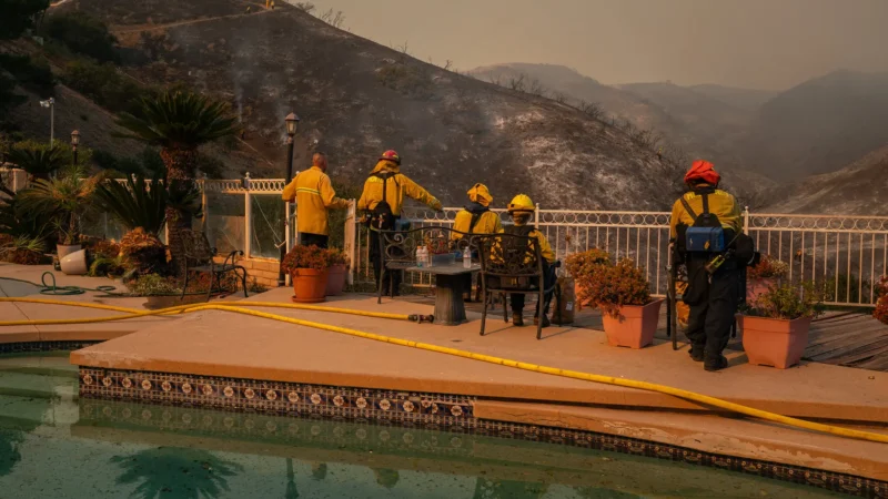 In Mandeville Canyon, firefighters rested with boxes of Gatorade and potato chips as aircrafts circled overhead, 